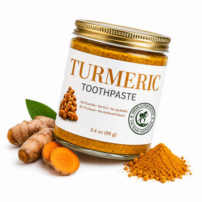 Jar of turmeric toothpaste with turmeric roots and powder on a white background