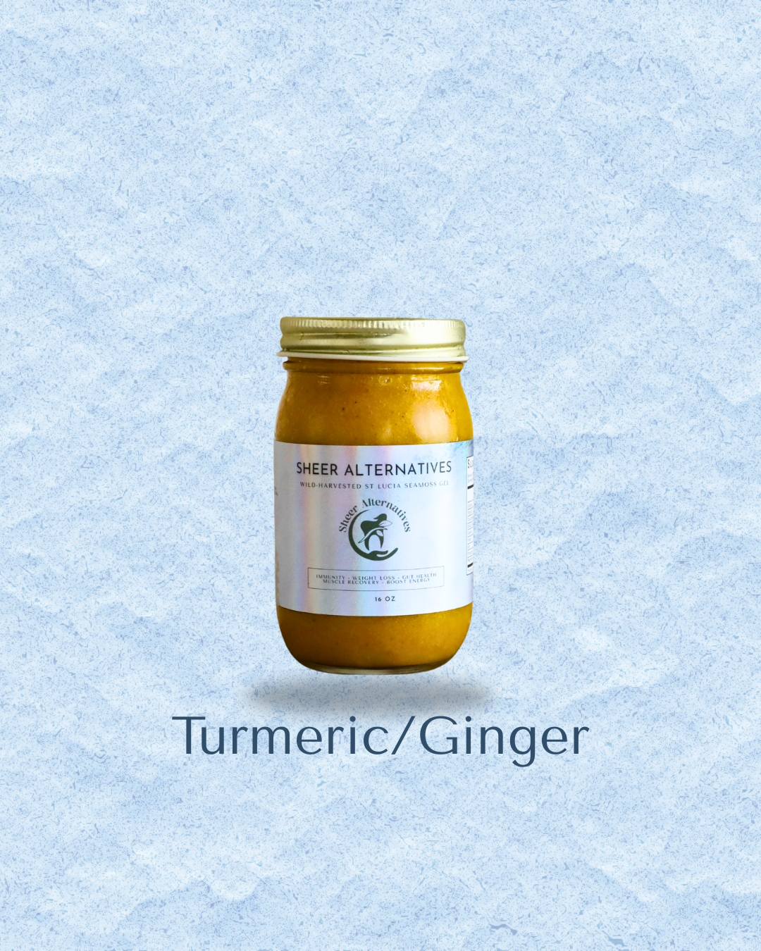A glass jar of Turmeric/Ginger paste by Sheer Alternatives, featuring a white label and a gold metal lid, set against a textured light blue background with the text 'Turmeric/Ginger' below.